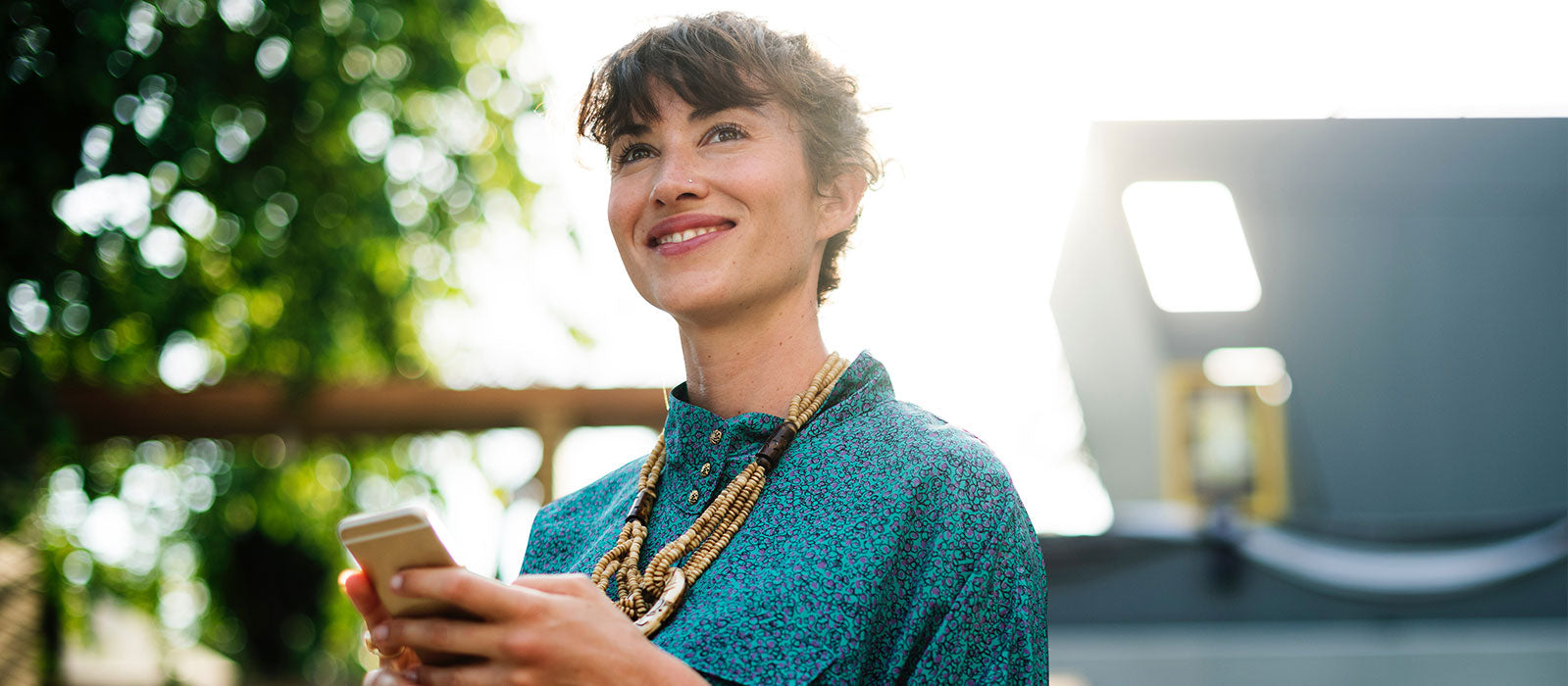 Professional young woman smiling and gazing while typing on her iphone